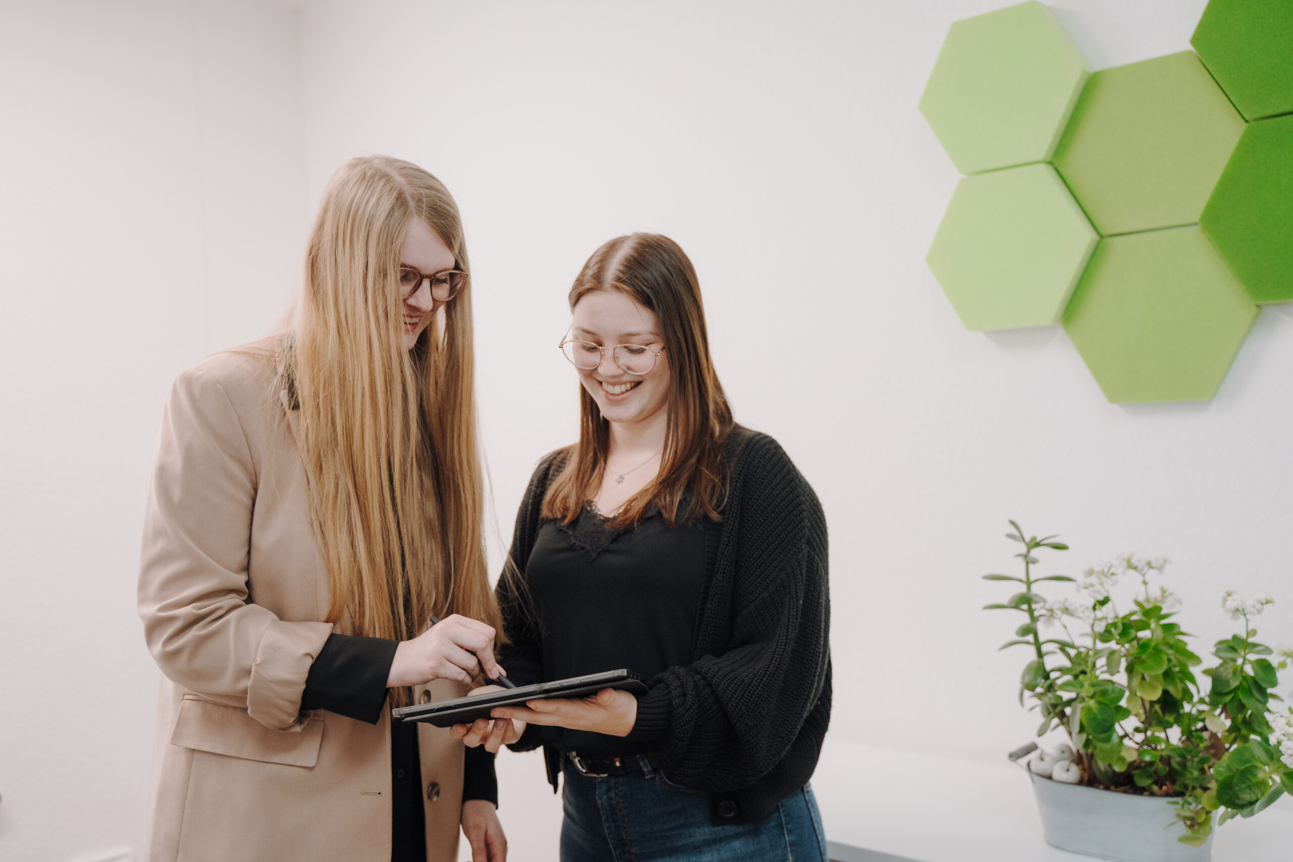zwei frauen schauen gemeinsam auf ein tablet