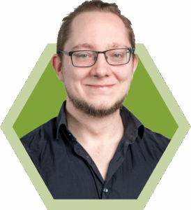 mann mit brille und dunklem hemd vor gruenem hintergrund