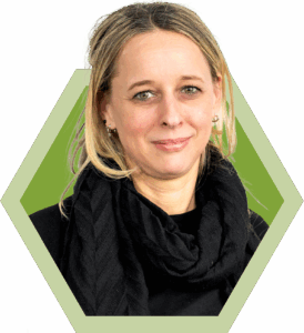 frau mit blondem zopf und schwarzem schal vor gruenem hintergrund